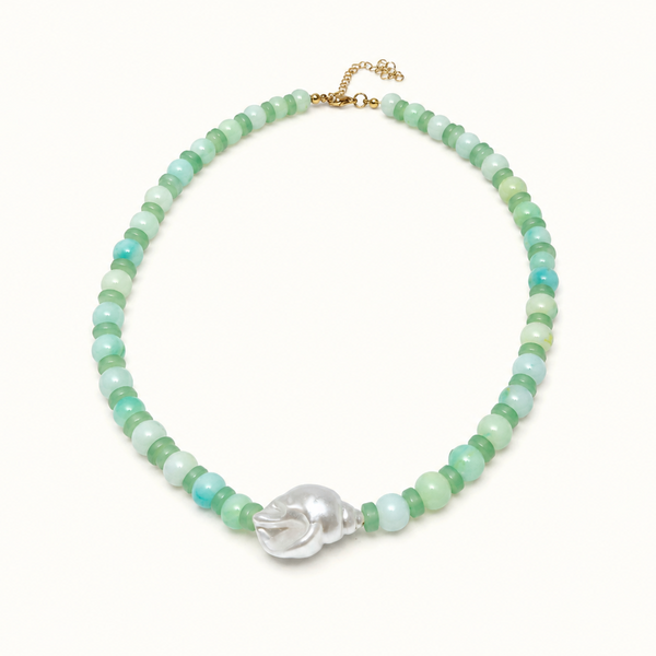 A beaded necklace featuring light green and turquoise-blue round beads, accented by a central silver-toned skull charm and a gold-tone clasp, displayed on a clean white background.