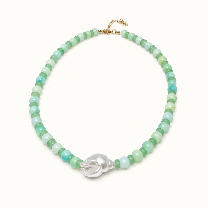A beaded necklace featuring light green and turquoise-blue round beads, accented by a central silver-toned skull charm and a gold-tone clasp, displayed on a clean white background.