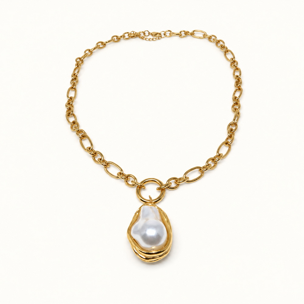 A gold chain necklace featuring a large, irregular white baroque pearl pendant set in a gold bezel, displayed on a clean white background.