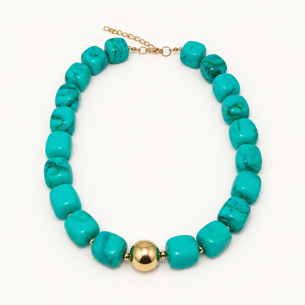 A turquoise beaded necklace with a single polished gold bead accent at the center, displayed on a clean white background.